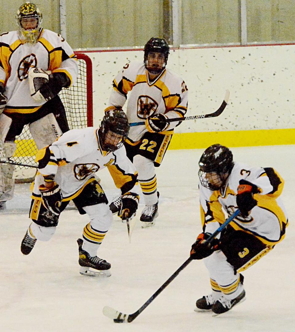 Evan Witt of the Watertown Lakers (3) grabs the puck as teammates Blair Boomsma (4), Brayson Bohling (22) and goalie Owen McBride look on during their South Dakota Amateur Hockey Association varsity boys game against the Sioux Falls Flyers on Friday night in the Maas Ice Arena.