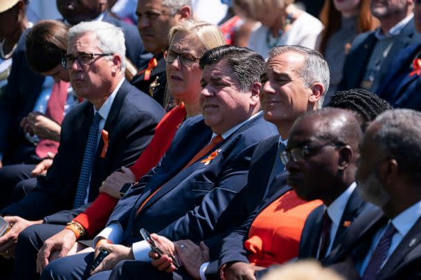 PHOTO: Gov. J.B. Pritzker listens as President Joe Biden speaks during an event to celebrate the passage of the 'Bipartisan Safer Communities Act,' a law meant to reduce gun violence, on the South Lawn of the White House, July 11, 2022, in Washington. (Evan Vucci/AP)