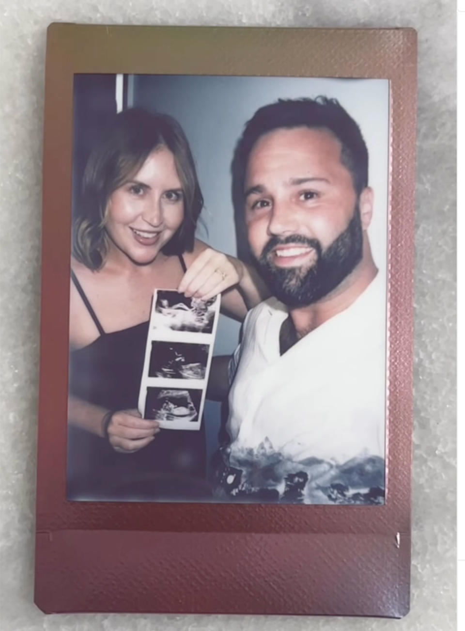Lauren Huntriss and Wade Burns holding up their baby scan