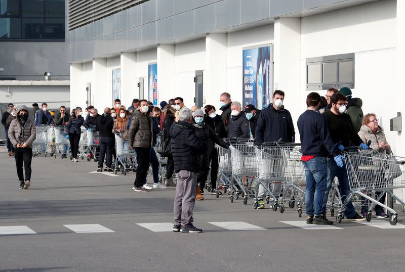 People queue at a supermarket outside the town of Casalpusterlengo