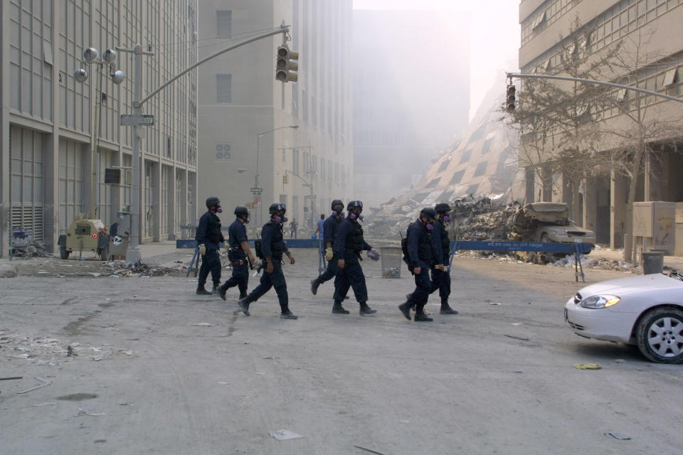 <p>New York Police Department members on patrol in the World Trade Center complex in New York. At center is the collapsed 7 World Trade Center on Sept. 13, 2001. (Photo: James Estrin/AFP/Getty Images) </p>