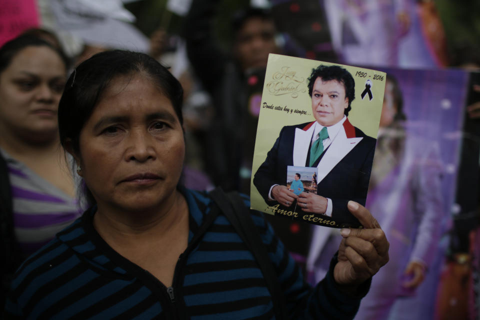 A woman holds an image of Mexican songwriter and singer Juan Gabriel during the Memorial at Palacio de Bellas Artes.