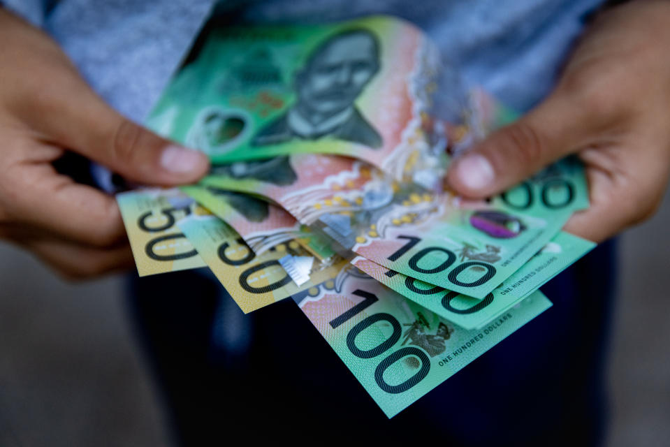 A young boy holding Australian dollars