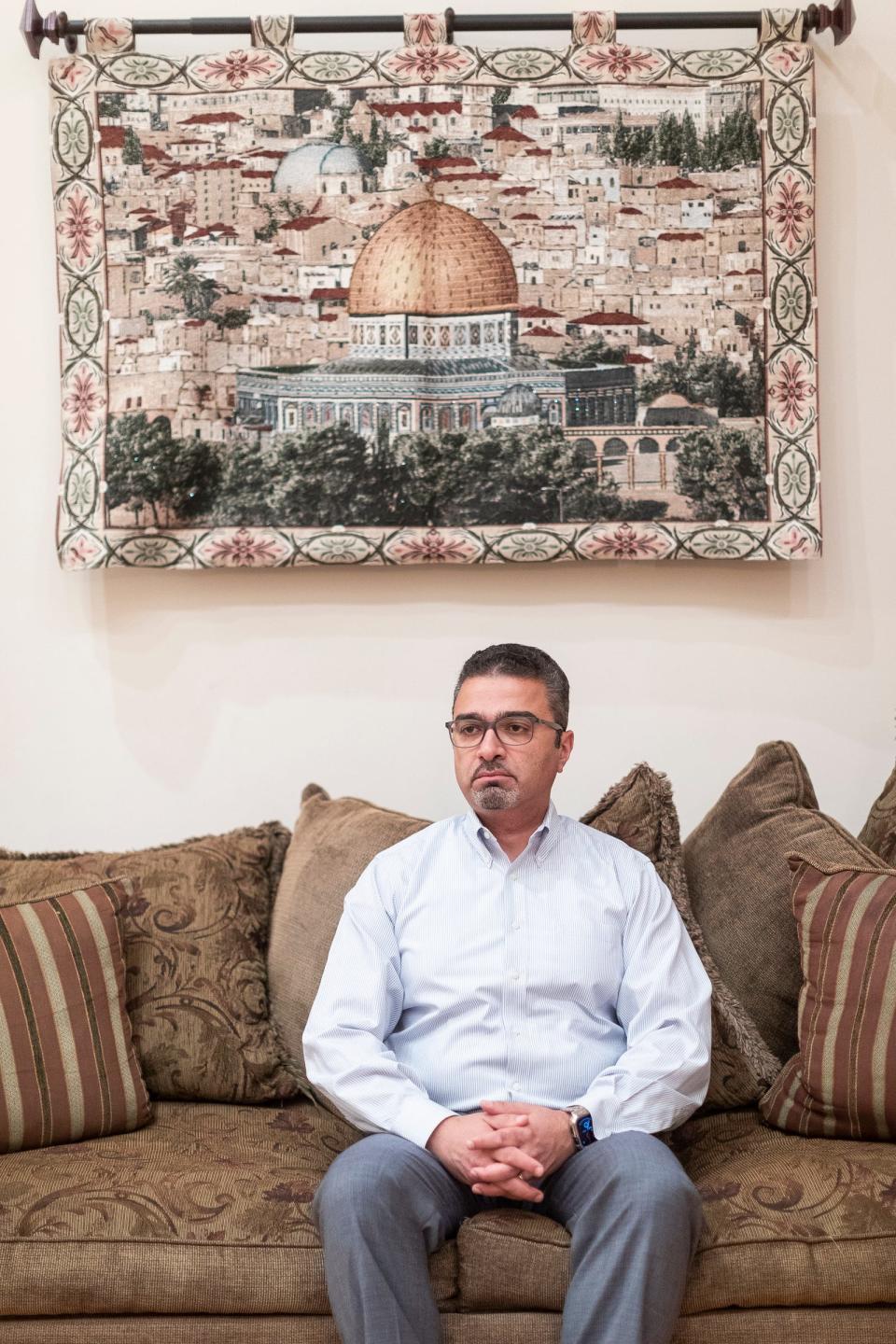 Dr. Emad Shehada, a Palestinian doctor sits under a picture of Jerusalem at his home in West Bloomfield on Thursday, Oct. 26, 2023.