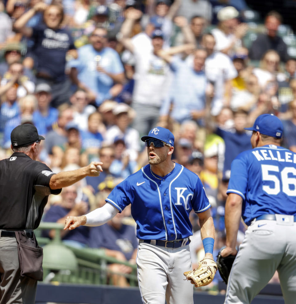 Kansas City Royals third baseman Hunter Dozier, center, argues with home plate umpire Lance Barksdale during the fifth inning of a baseball game against the Milwaukee Brewers, Wednesday, July 21, 2021, in Milwaukee. (AP Photo/Jeffrey Phelps)