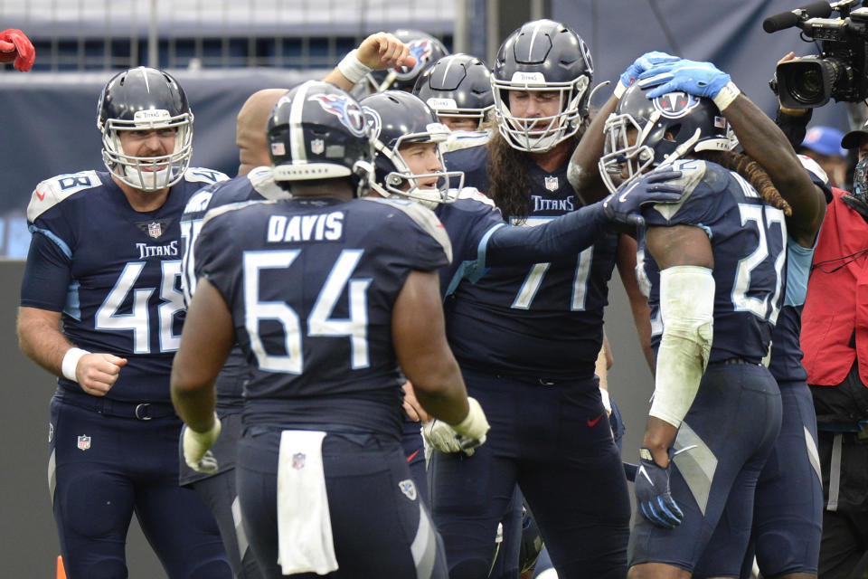 Tennessee Titans running back Derrick Henry (22) is mobbed by teammates after Henry scored the winning touchdown against the Houston Texans in overtime of an NFL football game Sunday, Oct. 18, 2020, in Nashville, Tenn. The Titans won 42-36. (AP Photo/Mark Zaleski)