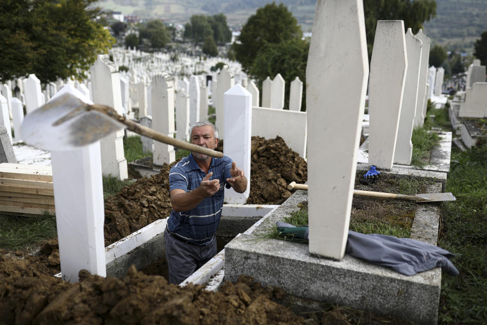 A man throws a shovel after digging graves for COVID-19 victims at the Bare cemetery in Sarajevo, Bosnia, Friday, Sept. 24, 2021. The COVID-19 rate of infections in Bosnia, a country where only about 12% of the population is fully vaccinated against COVID-19, is on a rising trend over the past weeks. (AP Photo)