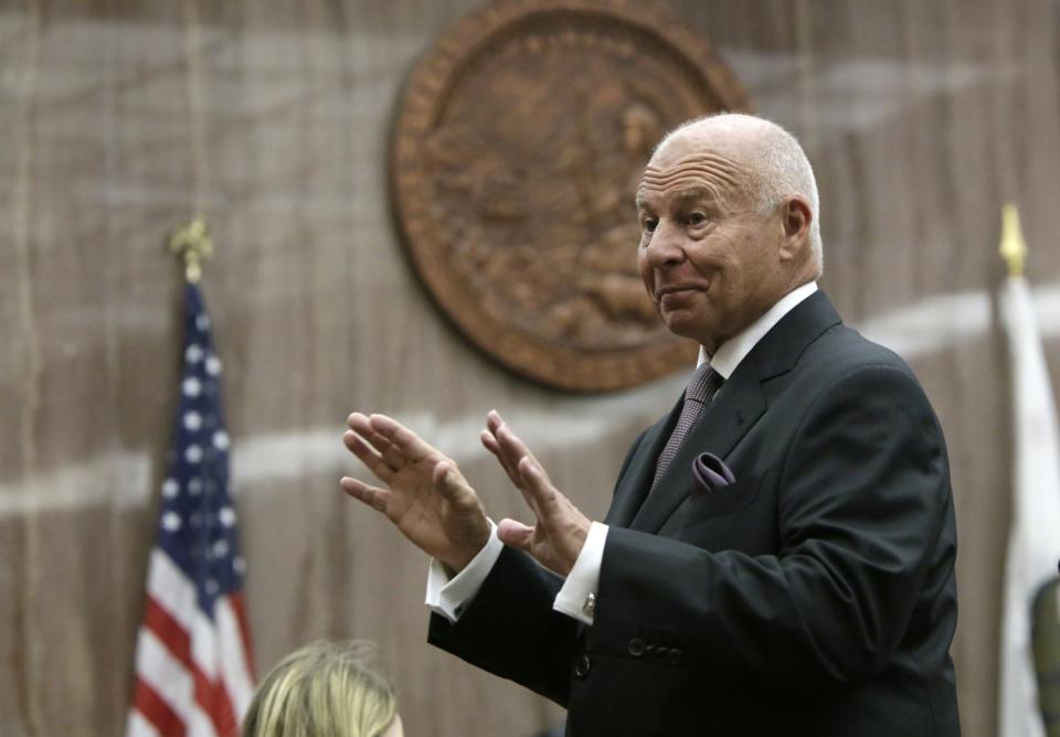 Tom Girardi, in an expensive suit, gestures with both hands while standing in a courtroom.