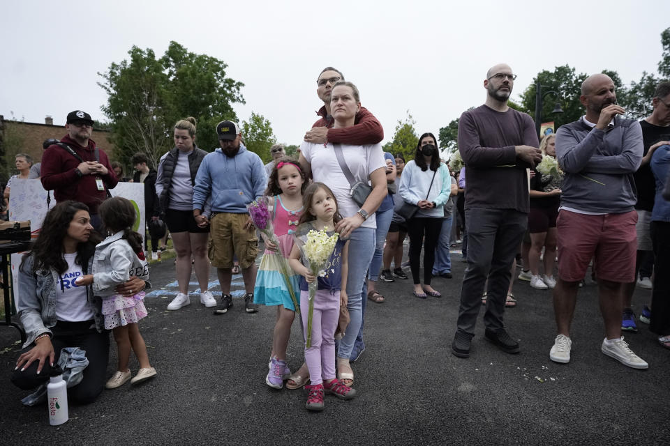 The Galbano family, from Highland Park, Ill., center, listens during a vigil in Highwood, Ill., for the victims of Monday's Highland Park's Fourth of July parade, Wednesday, July 6, 2022. (AP Photo/Charles Rex Arbogast)