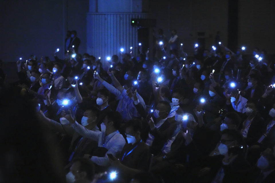 Attendees light their phones as John Lee, former No. 2 official in Hong Kong, and the only candidate for the city's top job, during his 2022 chief executive electoral campaign rally in Hong Kong, Friday, May 6, 2022. China is moving to install lee as the new leader of Hong Kong in the culmination of a sweeping political transformation that has gutted the Asian financial center's democratic institutions and placed it ever more firmly under Beijing's control. (AP Photo/Kin Cheung)