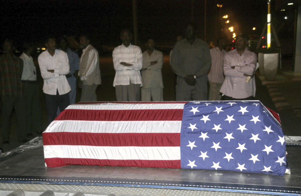 FILE - Sudanese men look at the flag-draped coffin of U.S. diplomat John Granville, who worked for the U.S. Agency for International Development, as it is received by U.S. officials in Khartoum, Sudan, on Jan. 3, 2008. The U.S. on Thursday, Feb. 2, 2023, asked the Sudanese government to re-arrest a man convicted of killing Granville in the country 15 years ago. (AP Photo/Abd Raouf, File)