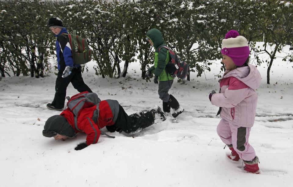 Ryan Rowell eats snow as he walks to school with his neighbors in Minneapolis, November 10, 2014. An arctic blast began to dump heavy snow in parts of the northern Rockies, Plains and the Great Lakes regions on Monday and meteorologists said temperatures are expected to plummet throughout the United States. (REUTERS/Eric Miller)