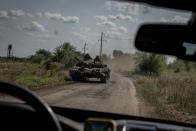 Ukrainian servicemen ride a tank near the village of Robotyne
