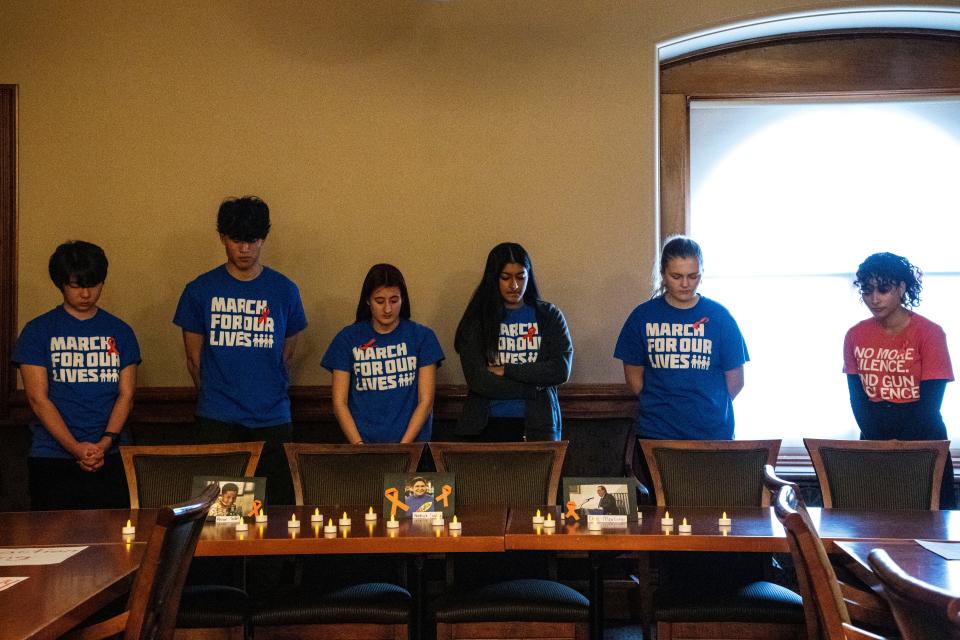 March for Our Lives organizers conduct a vigil and observe a moment of silence at the Iowa Capitol on Saturday, Jan. 27, 2024, in Des Moines. They stand near photos of gun violence victims, including Ahmir Jolliff and Dan Marburger, who died at Perry High School.