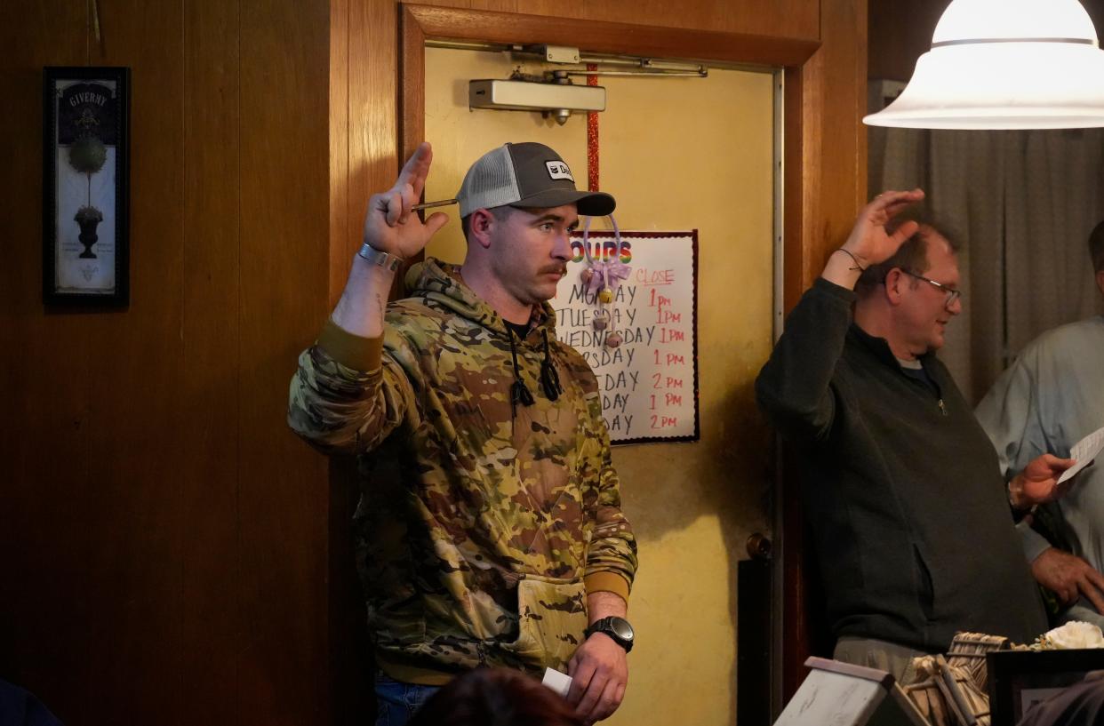 Spencer Gull raises his hand during the caucus inside Thoma Dairy Bar.