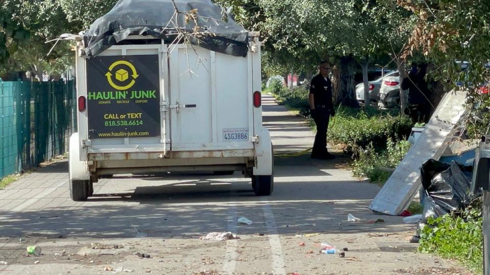 LAPD officers and sanitation workers remove an encampment on Friday after the storms (Carla Orendorff)