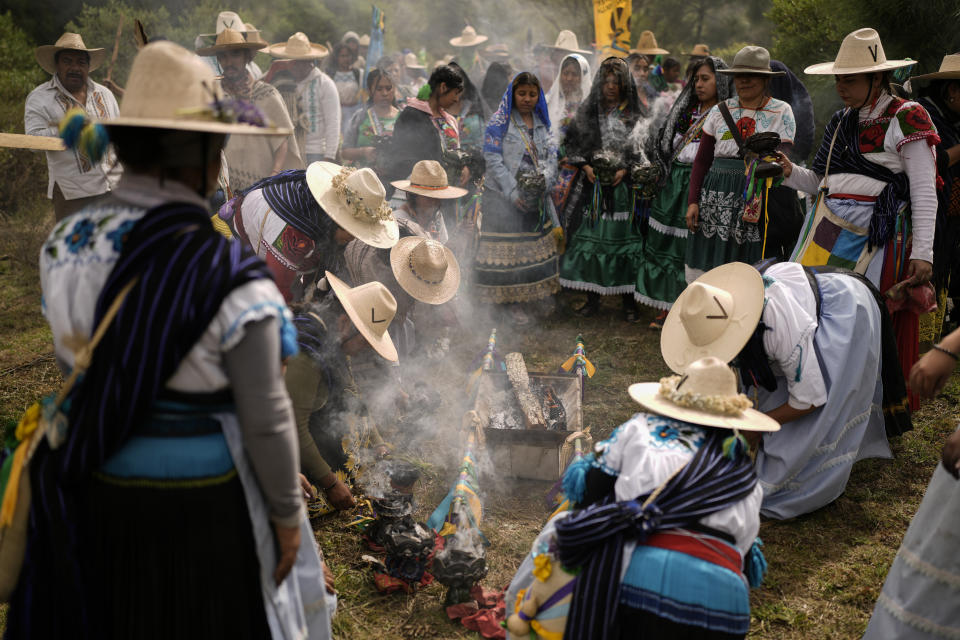 Mujeres indígenas purépechas queman incienso de copal durante una parada de descanso mientras caminan desde Erongarícuaro, donde los residentes mantuvieron viva una llama durante un año, hasta Ocumicho en el estado de Michoacán, México, el miércoles 31 de enero de 2024. (AP Foto/Eduardo Verdugo)