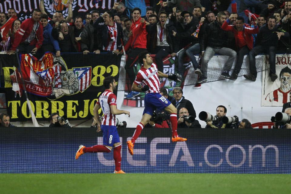 Atletico's Diego Costa, centre, celebrates his goal during a Champions League last 16 second leg soccer match between Atletico Madrid and AC Milan, at the Vicente Calderon stadium in Madrid, Tuesday, March 11, 2014. (AP Photo / Andres Kudacki)