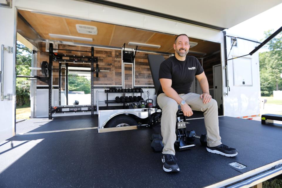 Jason Cotsoridis, owner of Agile Fitness, takes a seat on an adjustable weight bench inside of his mobile gym which he drives to his clients for personalized training.
