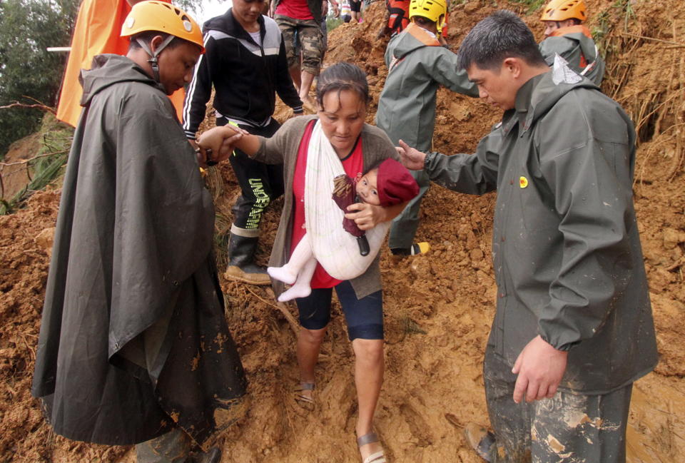 <p>Rescuers assist a mother and her child as they evacuate to safer grounds following landslides that hit Itogon township, Benguet province in the northern Philippines due to Typhoon Mangkhut Sunday, Sept. 16, 2018.<br>The landslides buried dozens of miners and isolated the township. Typhoon Mangkhut barreled into southern China on Sunday after lashing the northern Philippines with strong winds and heavy rain that left more than dozens dead from landslides and drownings.<br>(Photo by Jayjay Landingin, AP) </p>