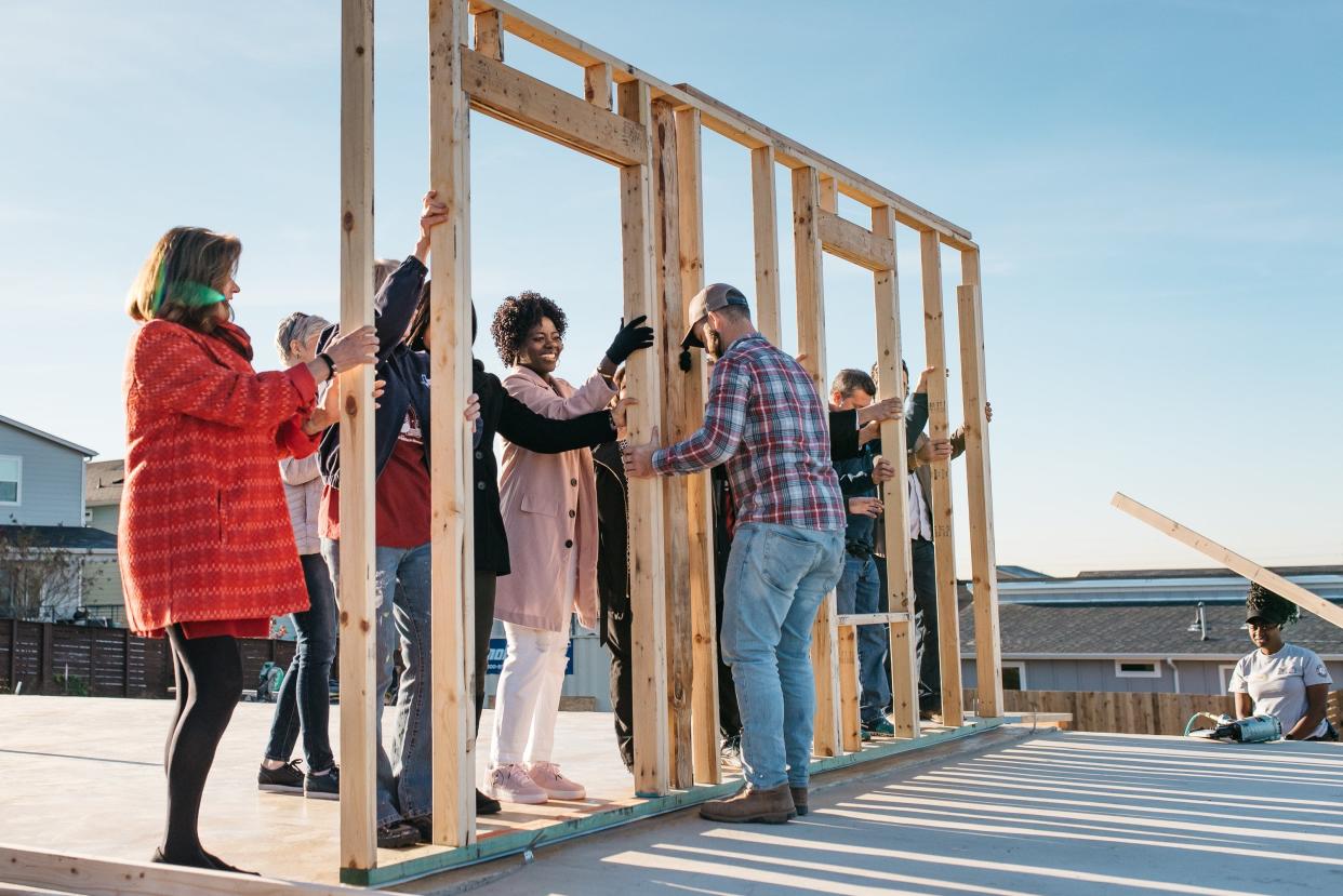 In this December, 2019 file photo, volunteers from the Austin Board of Realtors Foundation and Habitat for Humanity raise the walls on an affordable home in East Austin for Tede Tchabou, center, and her two children. [Photo courtesy Austin Board of Realtor/St. Laurent Photography]