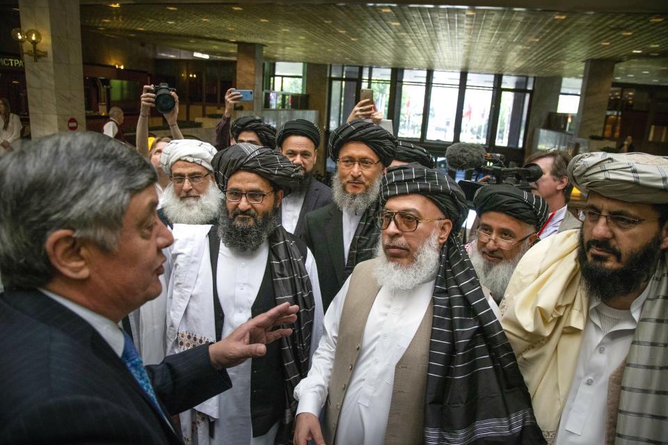FILE - In this file photo taken on Tuesday, May 28, 2019, Russian presidential envoy to Afghanistan Zamir Kabulov, left, speaks to Mullah Abdul Ghani Baradar, the Taliban group's top political leader, third left, Sher Mohammad Abbas Stanikzai, the Taliban's chief negotiator, third right, and other members of the Taliban delegation prior to their talks in Moscow, Russia. With talks between the Afghan government and the Taliban stalled and Washington reviewing its options, Russia has stepped up its diplomatic efforts to push peace in Afghanistan making the rounds of regional players, including in Pakistan on Friday, as well as meeting Taliban and senior Afghan officials. (AP Photo/Alexander Zemlianichenko, File)