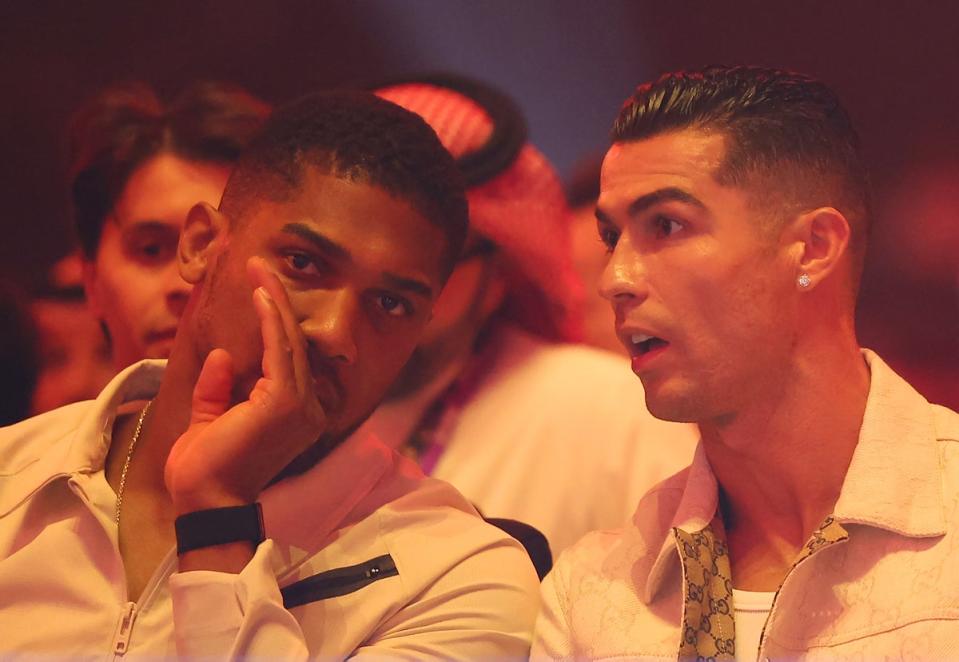 Joshua (izquierda) viendo Fury vs Usyk desde el ring con Cristiano Ronaldo (Getty)
