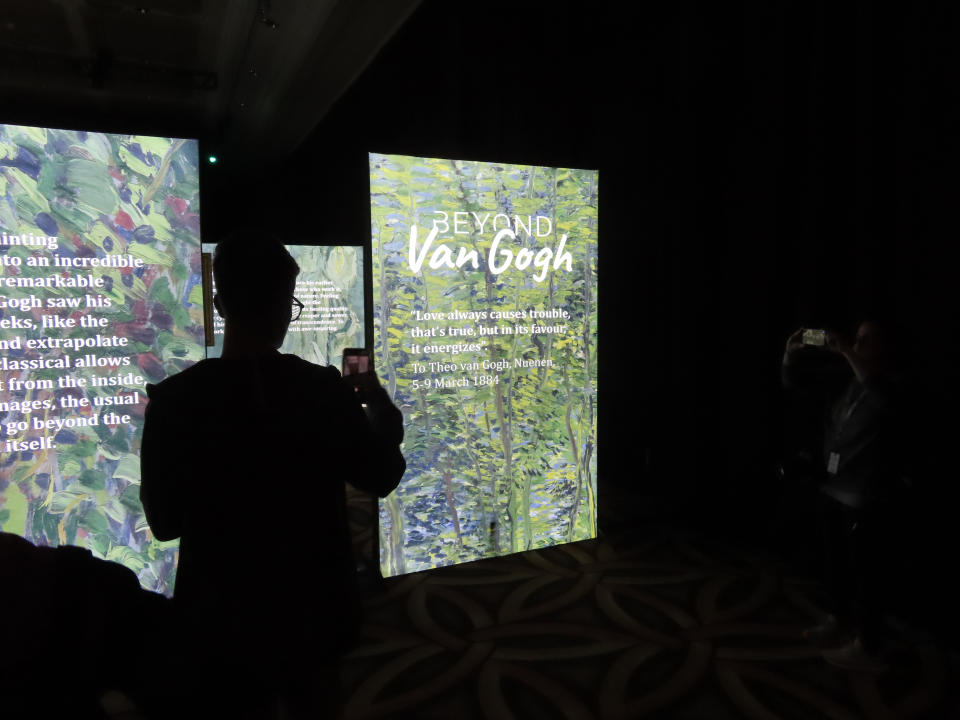 A spectator takes a cell phone photo during a preview of the "Beyond Van Gogh" exhibit at Hard Rock casino in Atlantic City, N.J., on Thursday, July 7, 2022. Some casinos are using fine art galleries or exhibitions to draw new customers who might not otherwise visit a gambling hall. (AP Photo/Wayne Parry)