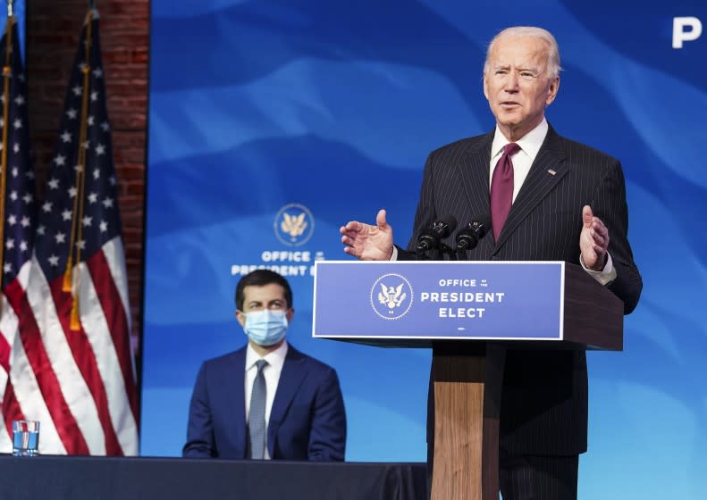 Former South Bend, Ind. Mayor Pete Buttigieg listens as President-elect Joe Biden announces Buttigieg as his nominee for transportation secretary during a news conference at The Queen theater in Wilmington, Del., Wednesday, Dec. 16, 2020. (Kevin Lamarque/Pool via AP)