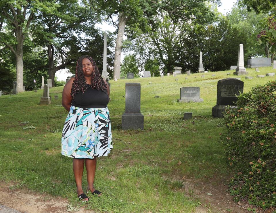 Kenyona "Sunny" Matthews stands next to the site of the unmarked graves of former slaves John Hansparker and his wife, Emily, and their daughter Helen at Oakwood Cemetery on June 10, 2021, in Cuyahoga Falls. A grave marker will be unveiled at the cemetery.