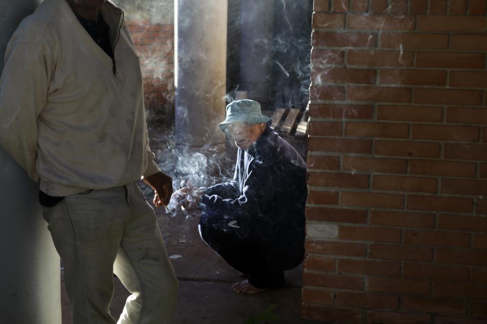 In this May 29, 2013 photo, a patient smokes in the courtyard of the Neuro-Psychiatric Hospital in Asuncion, Paraguay. Under funding plagues the hospital. It recently hit a crisis when the hospital couldn’t even buy food and there were no psychiatric drugs for ambulatory patients, only inpatients, according to hospital director Teofilo Villalba. (AP Photo/Jorge Saenz)