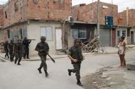 Militares y miembros de la unidad policial especial BOPE (de negro) aseguran las calles de la 'Favela da Mare', un complejo de 'favelas' al norte de Río de Janeiro, el 26 de marzo de 2014 (AFP | Christophe Simon)