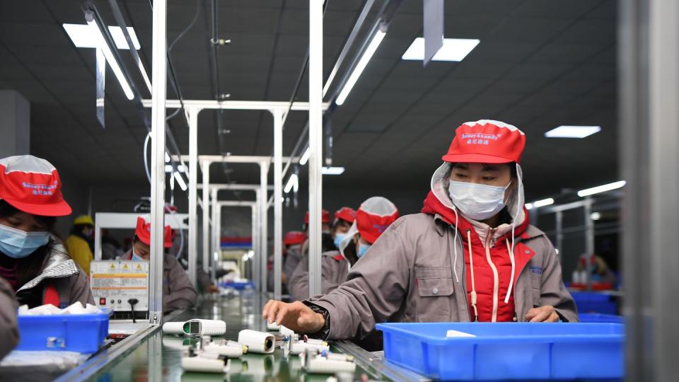 Menschen arbeiten in einer Fabrik am Fließband. Bei dem neuen Gesetz geht es auch um die Vermeidung von Ausbeutung und Kinderarbeit in weltweiten Lieferketten.