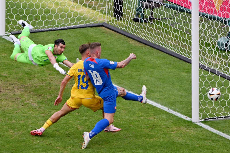 Slovák Juraj Kuca (vpravo) a Rumun Denis Dragos zápasia o loptu počas futbalového zápasu skupiny E Euro 2024 medzi Slovenskom a Rumunskom vo Frankfurtskej aréne.  Torsten Sells/dpa