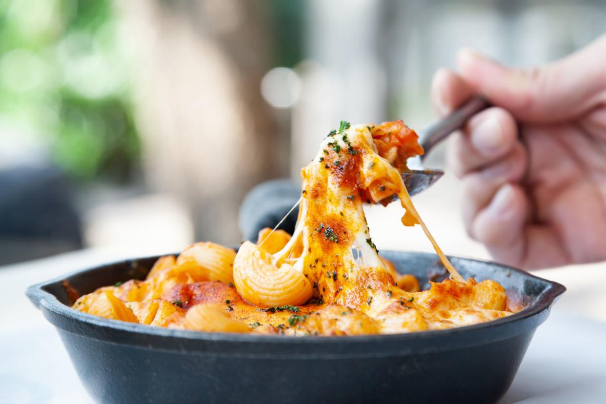 Baked macaroni and cheese with fresh tomato sauce served on hot pan