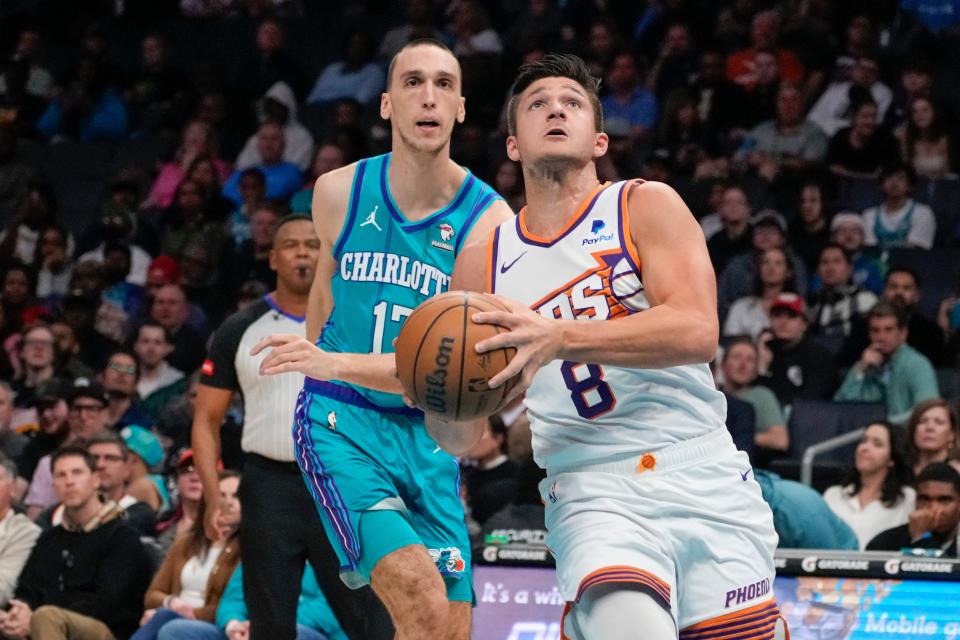 Phoenix Suns guard Grayson Allen (8) drives to the basket against Charlotte Hornets forward Aleksej Pokusevski (17) during the first quarter at Spectrum Center in Charlotte on March 15, 2024.