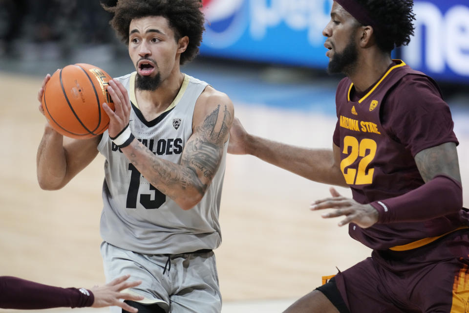 Colorado guard J'Vonne Hadley, left, looks to pass the ball as Arizona State forward Warren Washington defends in the second half of an NCAA college basketball game Thursday, Dec. 1, 2022, in Boulder, Colo. (AP Photo/David Zalubowski)