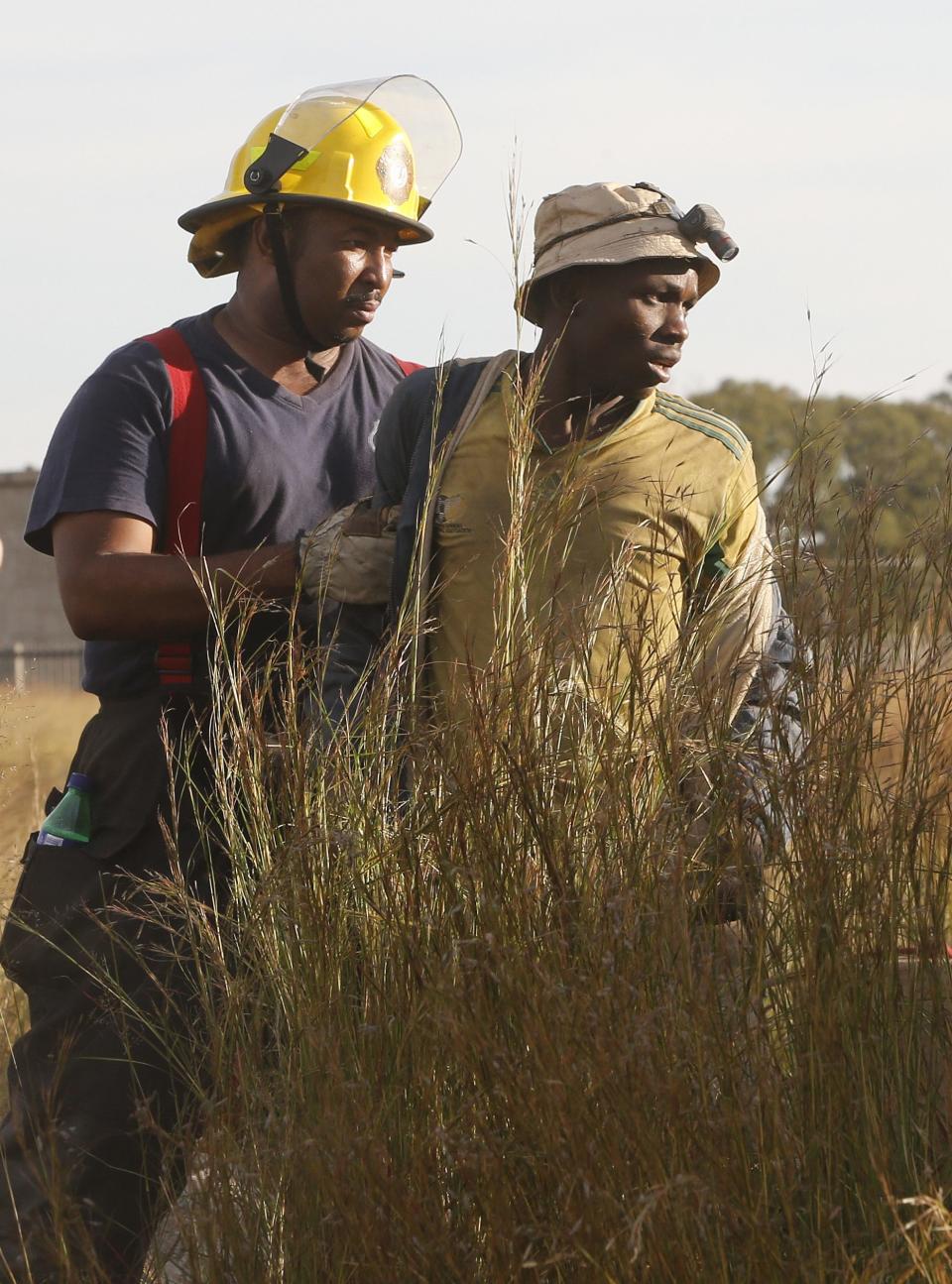 A suspected illegal miner is led away after being rescued from an abandoned gold shaft in Benoni