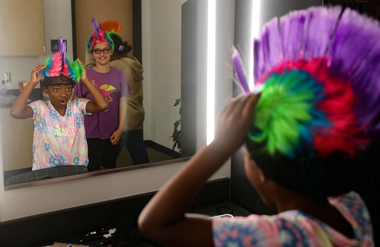 Faith Peace, 8, looks in the mirror as she excitedly pulls on her Oompa Loompa wig for the first time during rehearsal for Central Kitsap School District's Willy Wonka at the CKHS Auditorium on Friday.