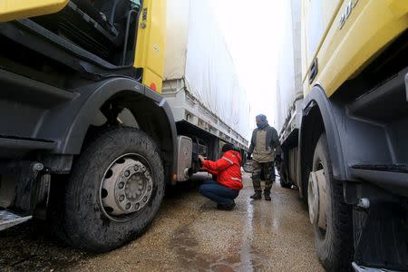 A rebel fighter inspects Red Crescent vehicles on their way to al Foua and Kefraya, in Idlib province, Syria January 11, 2016. REUTERS/Ammar Abdullah