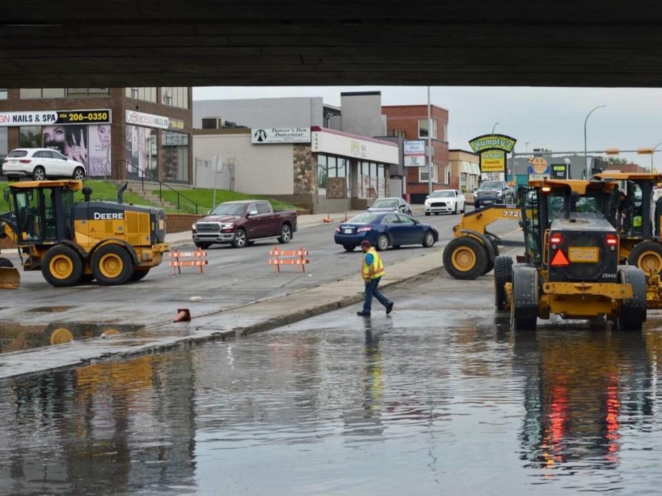 City of Regina crews work to move debris from underpass grates on Albert Street.  (Alexander Quon/CBC - image credit)