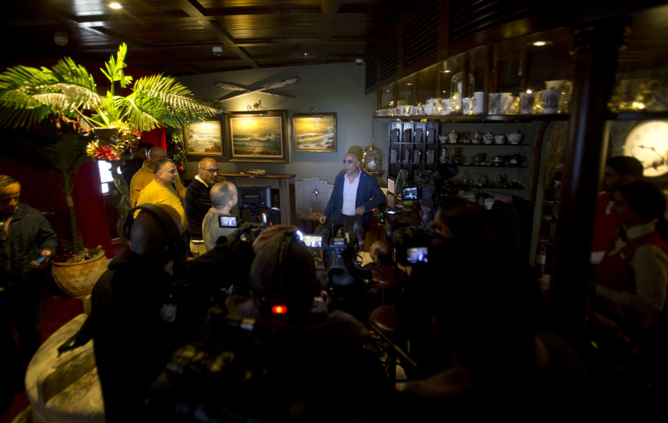 Wisam Salsa, general manager of the Walled Off hotel, speaks to journalists about a new artwork dubbed "Scar of Bethlehem" by the artist Banksy that is displayed in hotel, in the West Bank city of Bethlehem, Sunday, Dec. 22, 2019. (AP Photo/Majdi Mohammed)