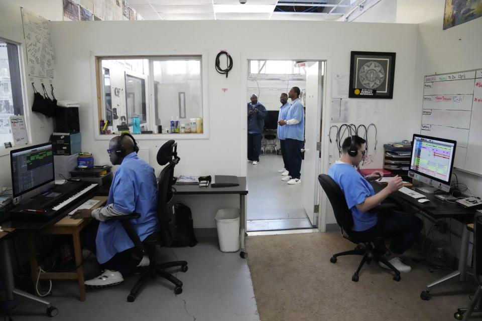 Incarcerated men work with keyboards and computer screens