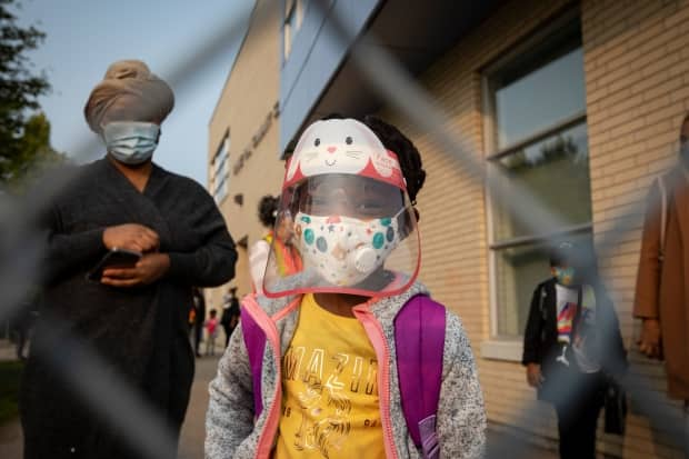 A Toronto elementary school student wears full PPE before heading into class last September. Students will continue to wear masks inside classrooms as part of Ontario's new plan. (Evan Mitsui/CBC - image credit)