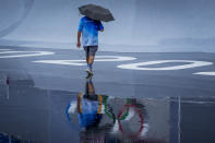 A venue official takes a look at the BMX Freestyle course after a training session was canceled due to rain, at the 2020 Summer Olympics, Tuesday, July 27, 2021, in Tokyo, Japan. (AP Photo/Ben Curtis)