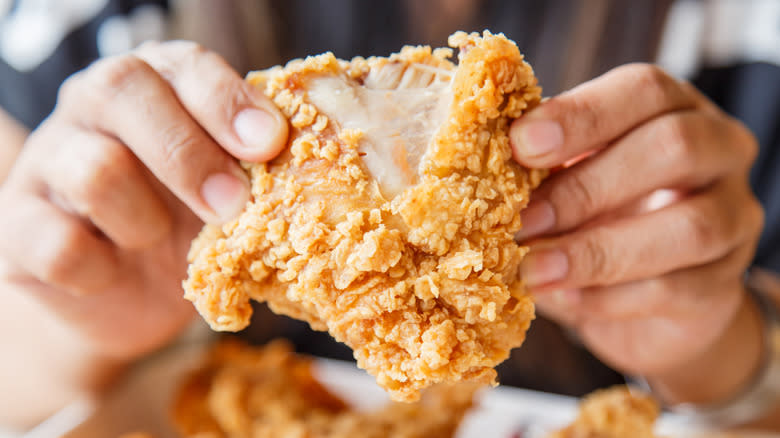 Fried chicken split with hands