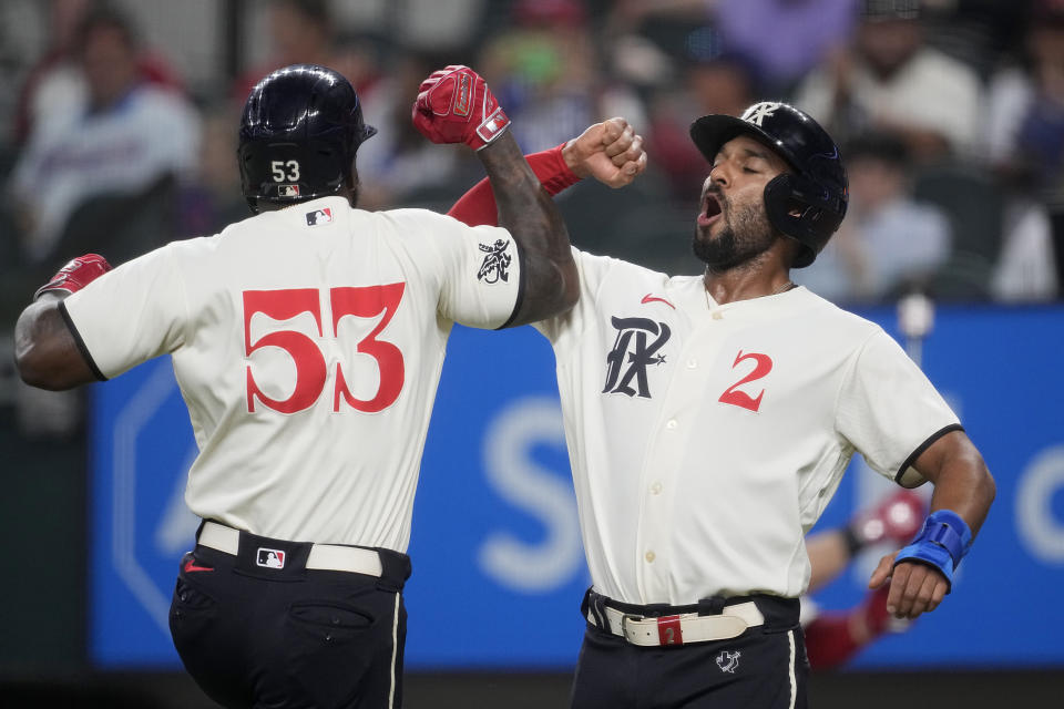 Texas Rangers' Adolis Garcia (53) and Marcus Semien (2) celebrate after a two-run home run by Garcia that also scored Semien in the first inning of a baseball game against the Minnesota Twins, Saturday, Sept. 2, 2023, in Arlington, Texas. (AP Photo/Tony Gutierrez)