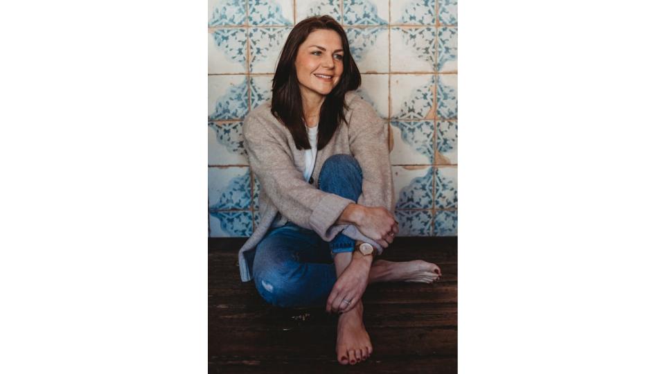 Woman sitting on the ground in jeans against pretty tiles