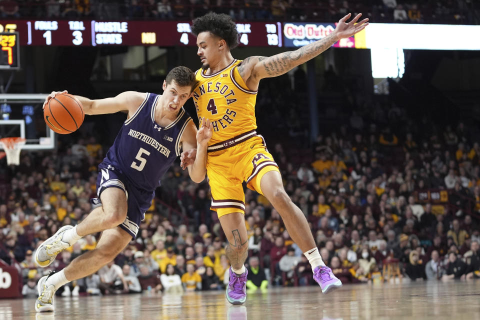 Northwestern guard Ryan Langborg (5) works toward the basket as Minnesota guard Braeden Carrington (4) defends during the second half of an NCAA college basketball game Saturday, Feb. 3, 2024, in Minneapolis. (AP Photo/Abbie Parr)