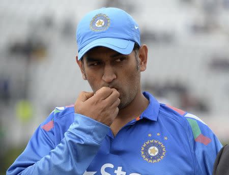 India's Mahendra Singh Dhoni looks on before the coin toss before the third one-day international cricket match against England at Trent Bridge cricket ground, Nottingham, England August 30, 2014. REUTERS/Philip Brown